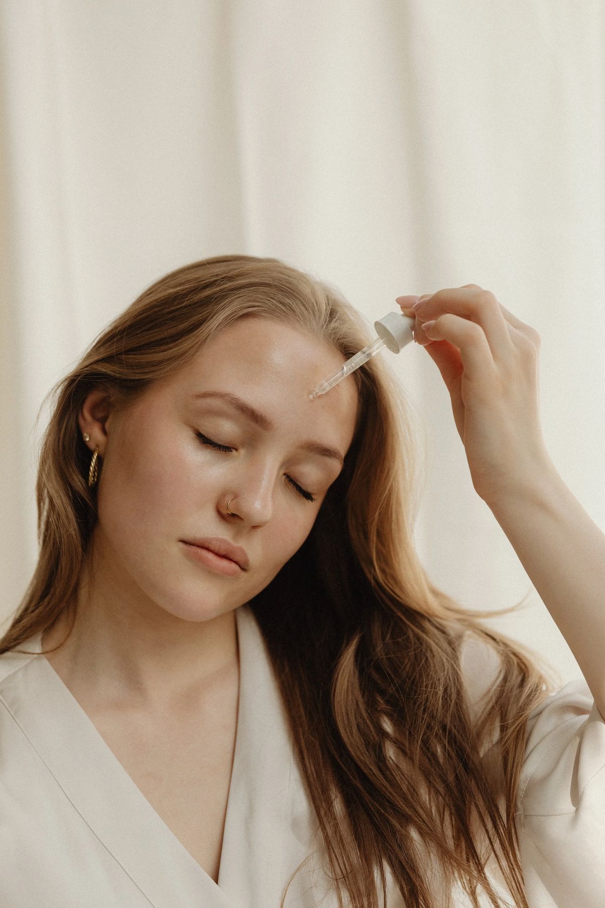 Woman applying a facial serum with a dropper